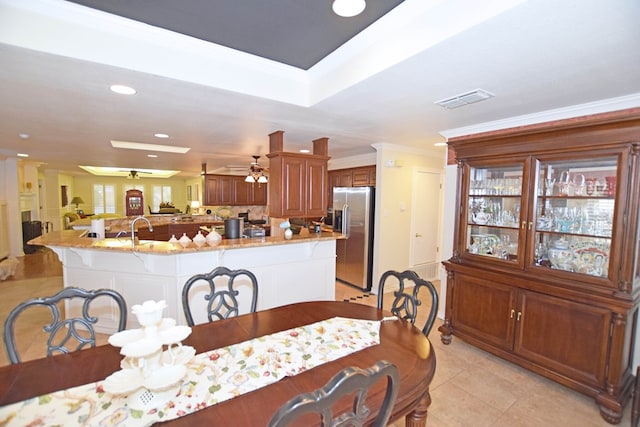 tiled dining room with ceiling fan, crown molding, and sink