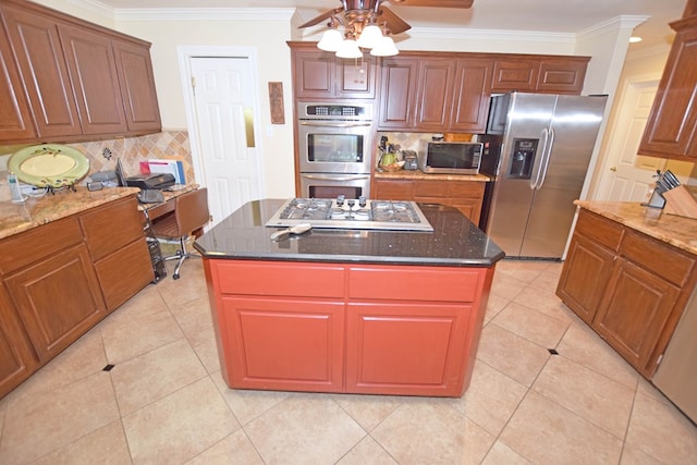 kitchen with tasteful backsplash, a kitchen island, ornamental molding, and appliances with stainless steel finishes