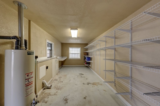 basement featuring gas water heater and a textured ceiling