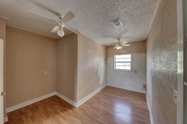 unfurnished room featuring ceiling fan, a textured ceiling, and light wood-type flooring