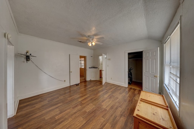 unfurnished bedroom with dark hardwood / wood-style flooring, a textured ceiling, and multiple windows