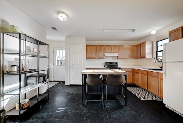 kitchen featuring electric range, sink, a center island, white refrigerator, and a kitchen bar