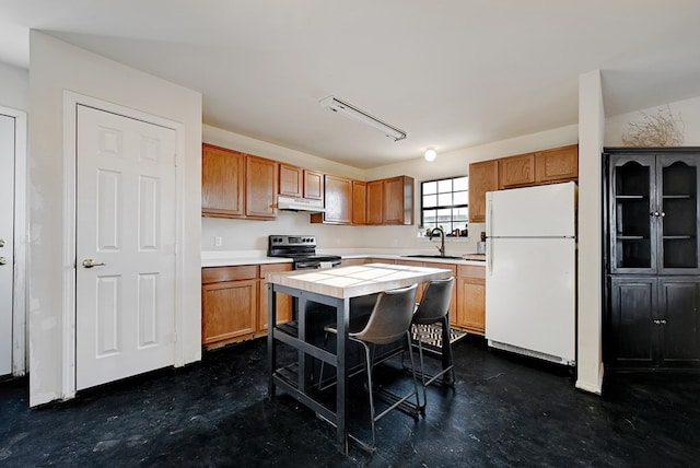 kitchen with stainless steel range with electric stovetop, sink, white refrigerator, a kitchen island, and tile counters