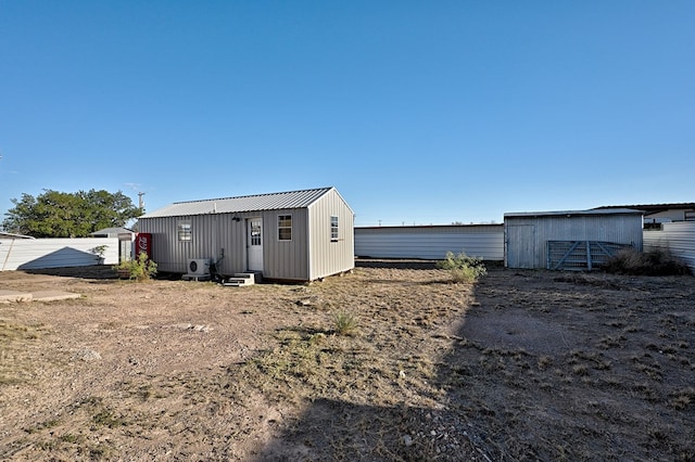 back of property featuring an outdoor structure