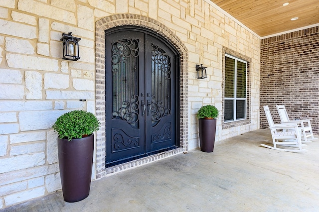 property entrance with a porch and french doors