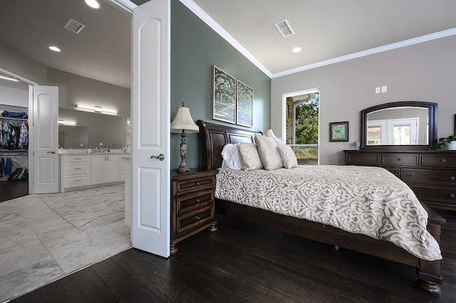 bedroom featuring a walk in closet, ensuite bathroom, crown molding, hardwood / wood-style flooring, and a closet