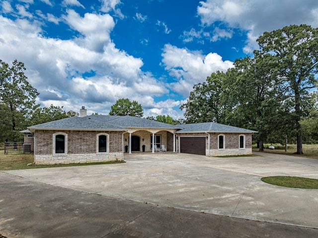 ranch-style home with covered porch and a garage