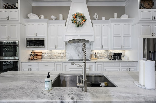 kitchen with backsplash, white cabinets, stainless steel appliances, and custom range hood