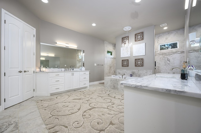 bathroom featuring a notable chandelier, vanity, and a bathing tub