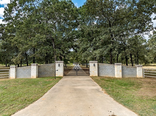 view of gate with a lawn