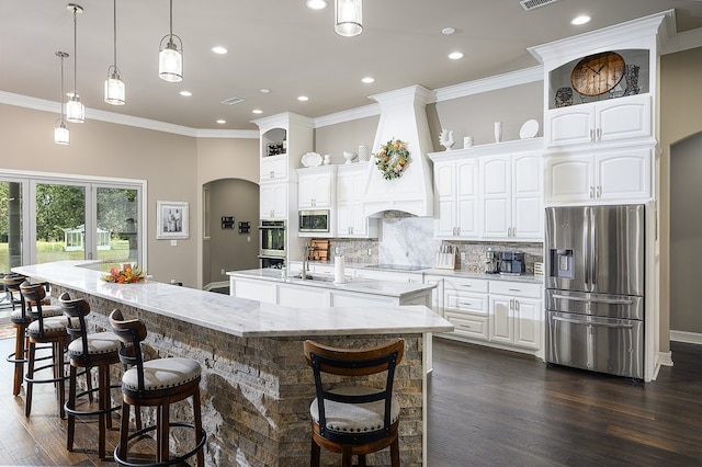 kitchen with white cabinets, appliances with stainless steel finishes, dark wood-type flooring, and a spacious island