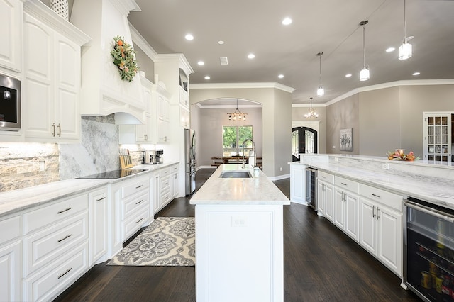 kitchen with white cabinetry, an island with sink, beverage cooler, and dark hardwood / wood-style floors