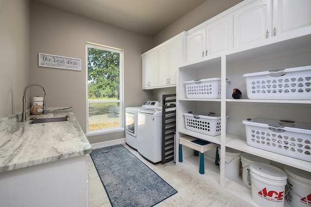 laundry room featuring cabinets, separate washer and dryer, and sink