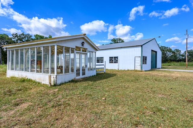 rear view of property featuring a lawn and an outdoor structure