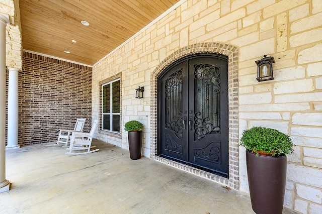 entrance to property featuring a porch and french doors