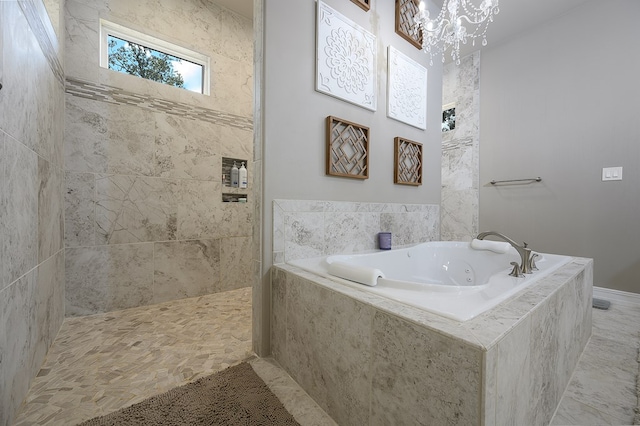 bathroom featuring independent shower and bath and a chandelier