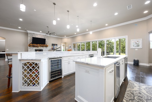 kitchen featuring white cabinetry, wine cooler, a wealth of natural light, and a large island