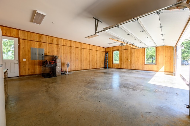 garage featuring wooden walls, electric panel, and a garage door opener