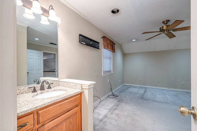 bathroom with lofted ceiling, a ceiling fan, a textured ceiling, baseboards, and vanity