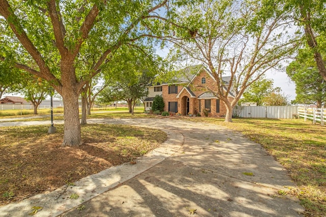 traditional home featuring brick siding and fence