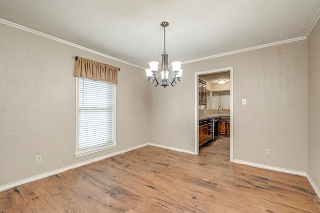 unfurnished dining area featuring a chandelier, a sink, light wood-type flooring, and ornamental molding