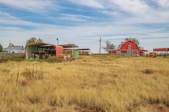 view of yard featuring a detached carport, a barn, and an outbuilding