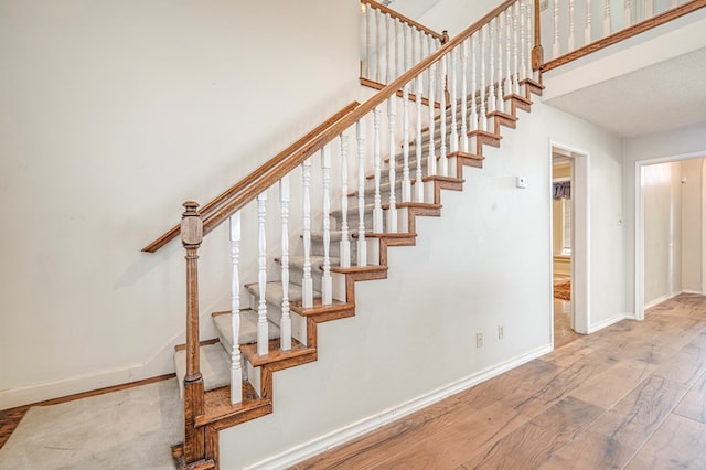 staircase with baseboards and hardwood / wood-style floors