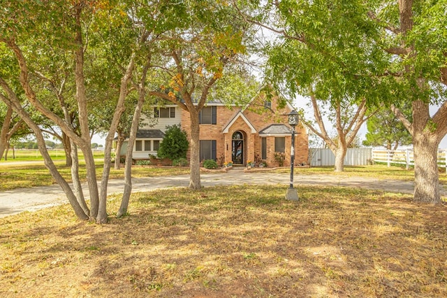 view of front of property with brick siding and fence