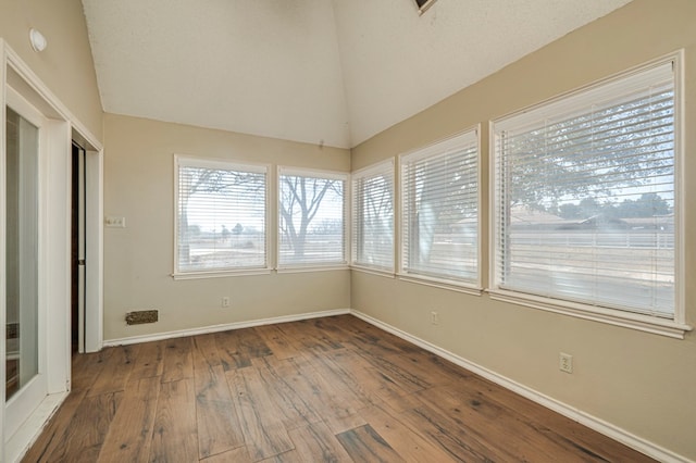 unfurnished sunroom featuring vaulted ceiling