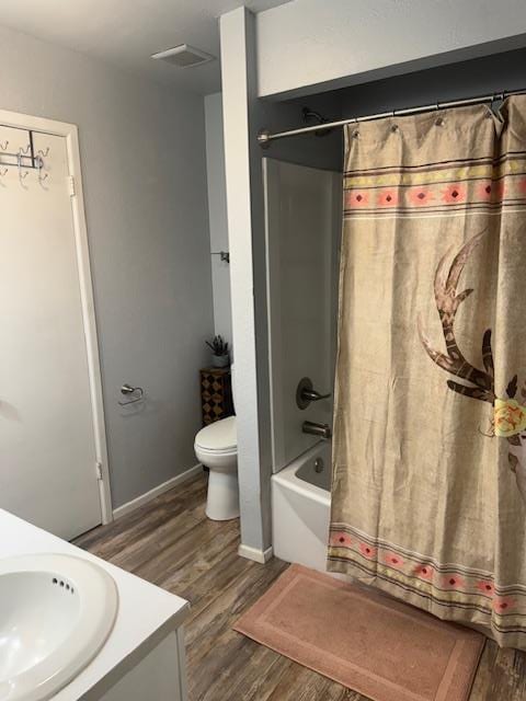 full bathroom featuring wood-type flooring, vanity, toilet, and shower / bathtub combination with curtain