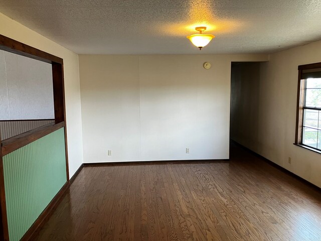 unfurnished room featuring hardwood / wood-style floors and a textured ceiling