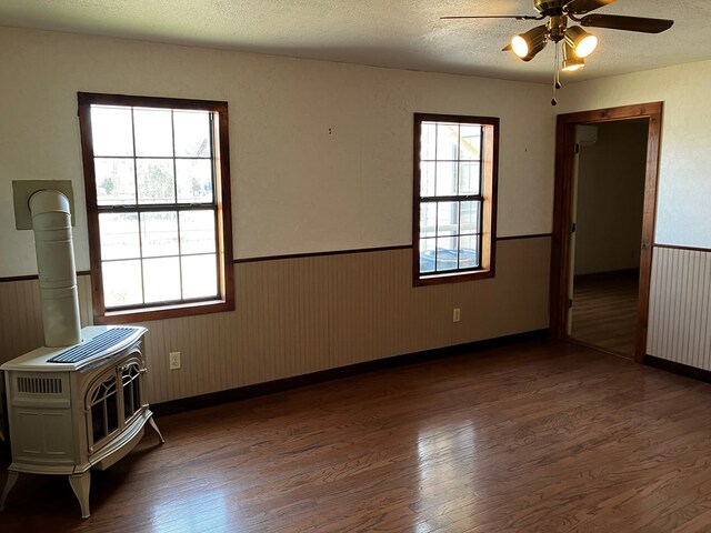 interior space featuring a textured ceiling, a wood stove, and dark hardwood / wood-style floors