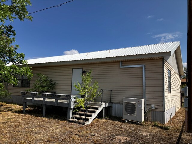 back of house with ac unit and a deck