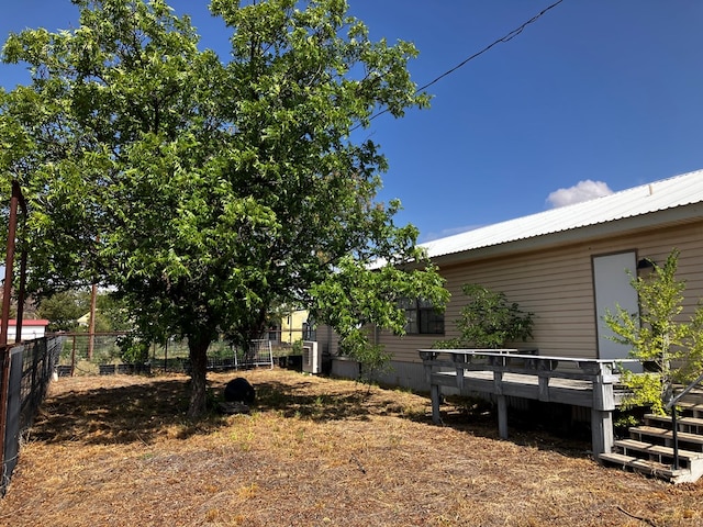 view of yard with central air condition unit and a wooden deck