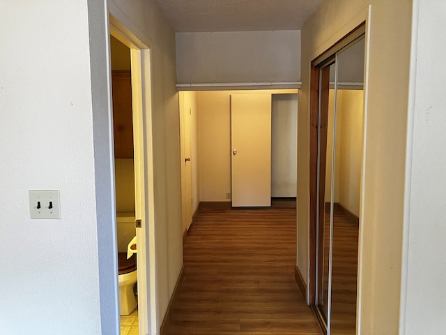 corridor featuring a textured ceiling and hardwood / wood-style flooring