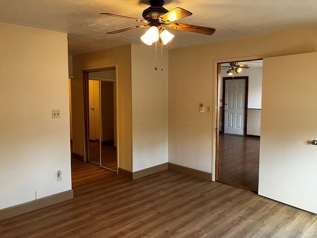 unfurnished room featuring ceiling fan, hardwood / wood-style floors, and a textured ceiling