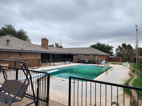 view of pool with a patio and a diving board