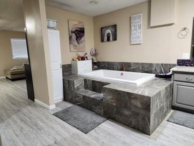 bathroom featuring a washtub, vanity, and hardwood / wood-style flooring