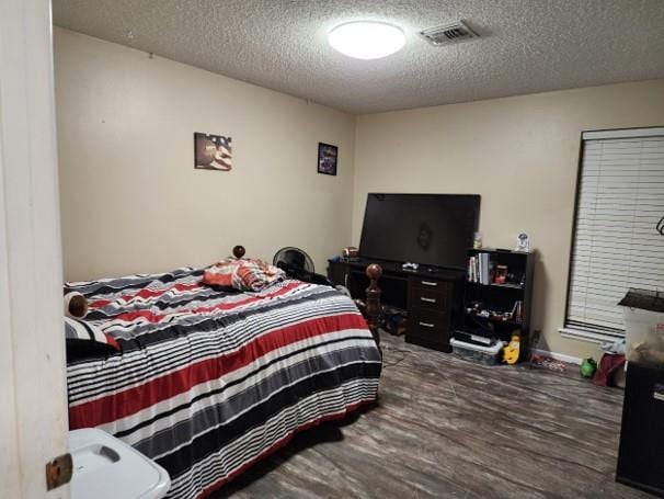 bedroom with a textured ceiling and hardwood / wood-style flooring