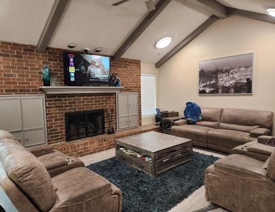 living room featuring ceiling fan, a fireplace, and lofted ceiling with beams