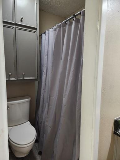 bathroom featuring toilet and a textured ceiling