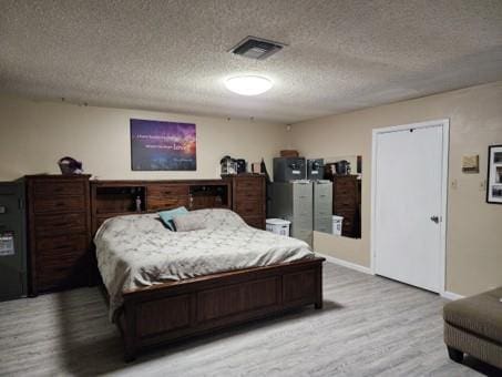 bedroom with a textured ceiling and light wood-type flooring