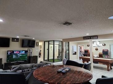 living room featuring a textured ceiling and billiards