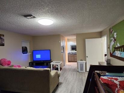 living room with light hardwood / wood-style flooring and a textured ceiling