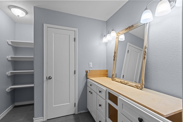 bathroom with tile patterned flooring, vanity, and baseboards