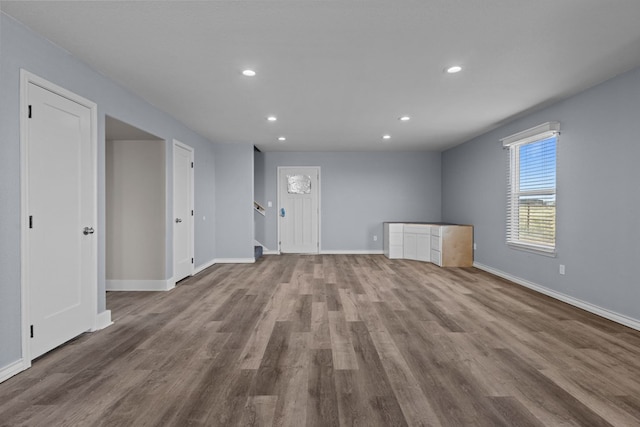 empty room with recessed lighting, baseboards, and wood finished floors