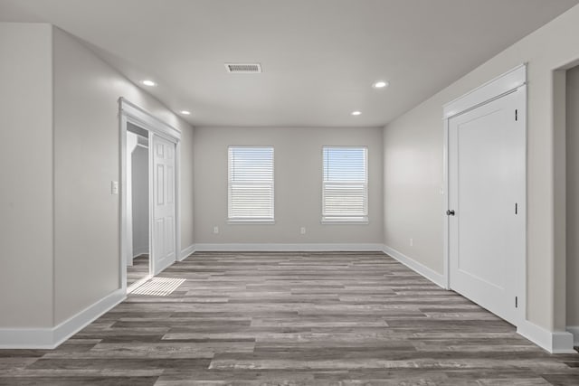 unfurnished room with baseboards, visible vents, wood finished floors, and recessed lighting