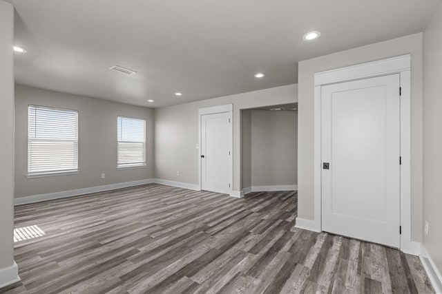 unfurnished bedroom with recessed lighting, a closet, visible vents, wood finished floors, and baseboards