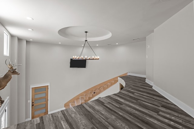 hallway featuring baseboards, wood finished floors, an upstairs landing, and recessed lighting