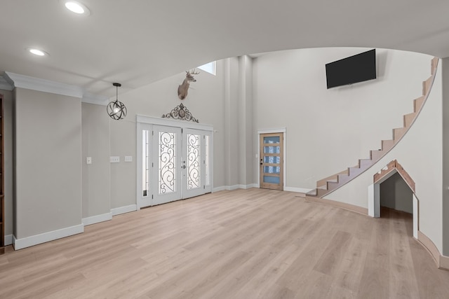 foyer featuring light wood-type flooring, stairs, and baseboards